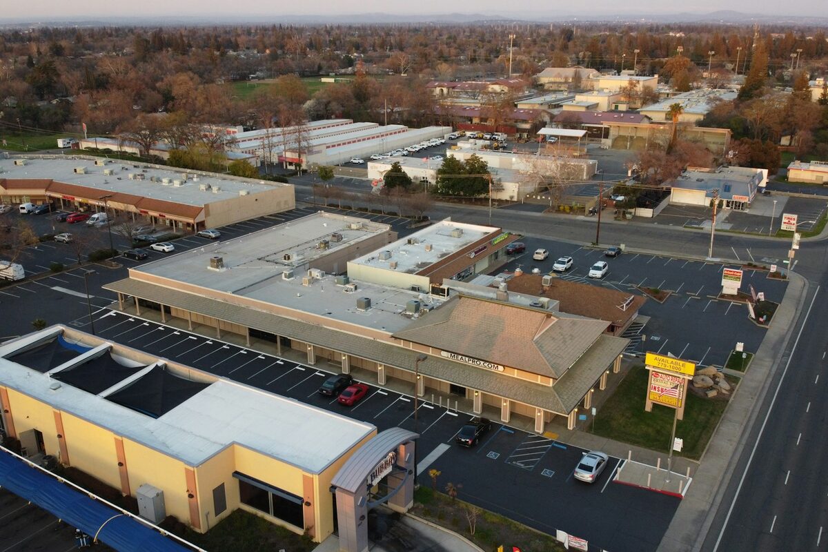 Illustrative aerial view of a suburban shopping and dining corridor