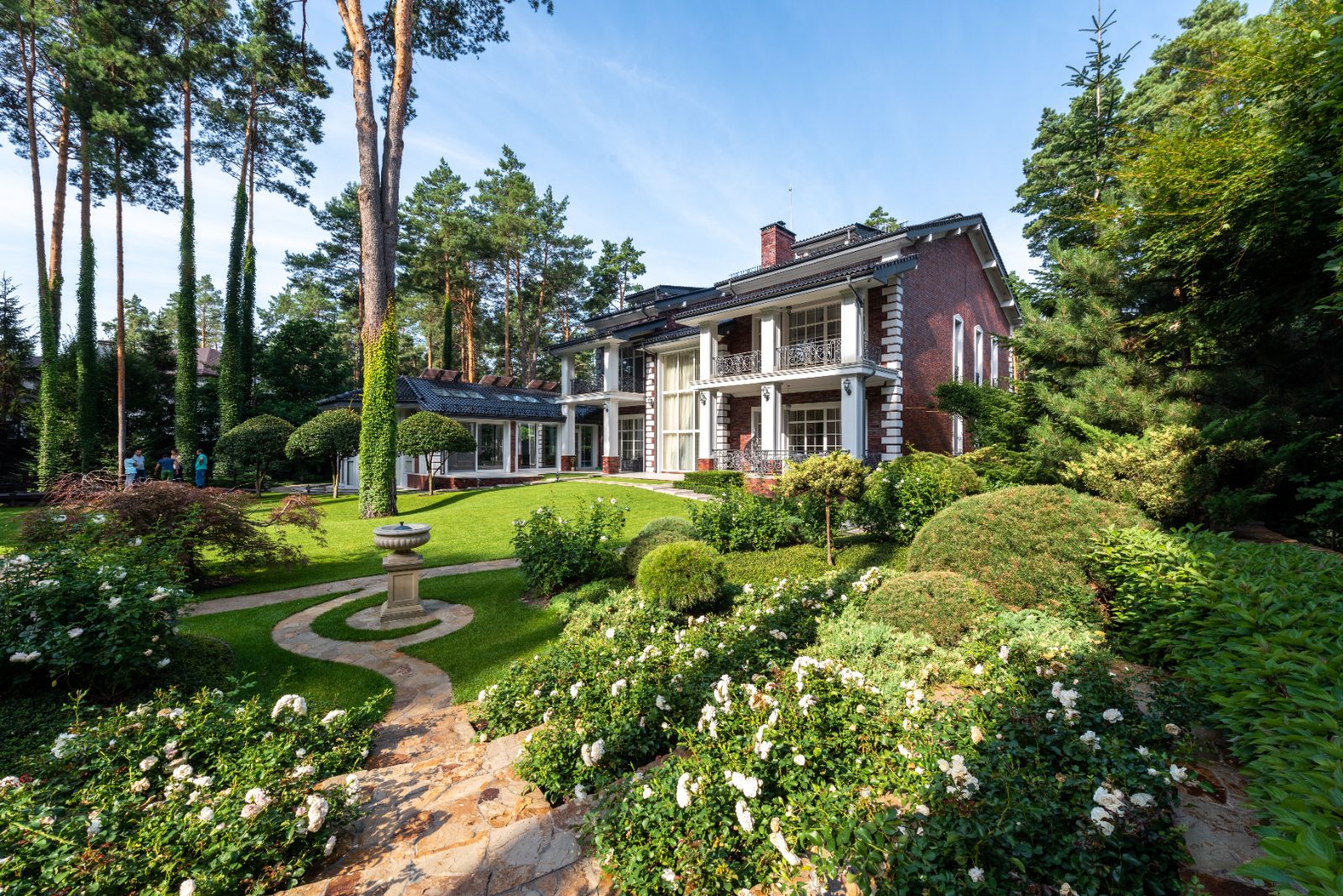 Elegant brick estate home with manicured garden pathway