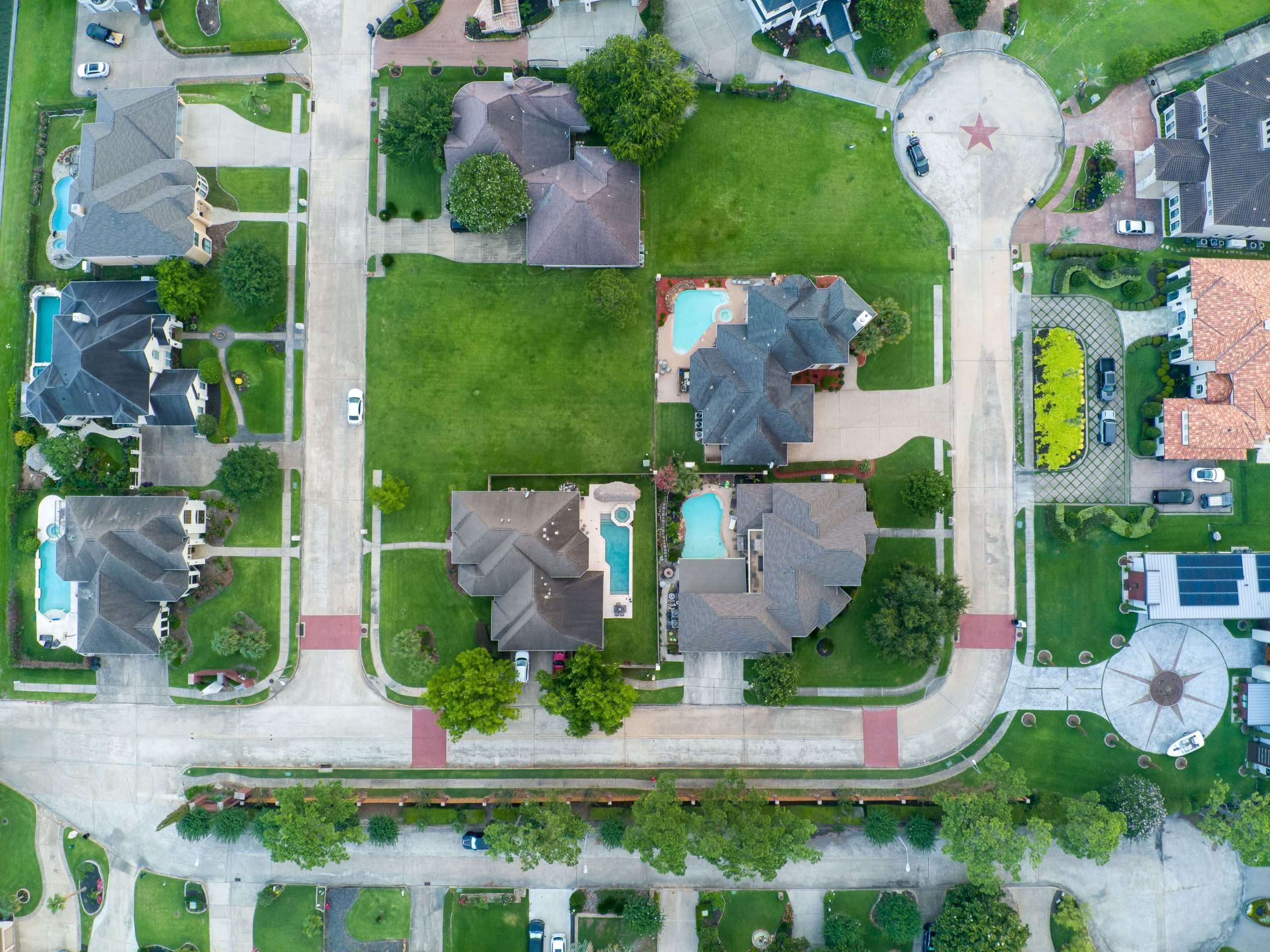Aerial view of a suburban neighborhood with tree-lined streets