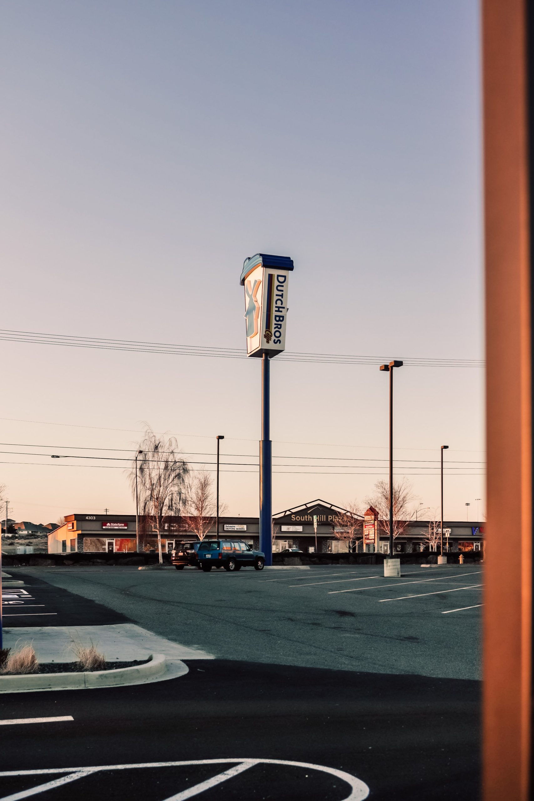 A commercial parking lot and sign at sunset