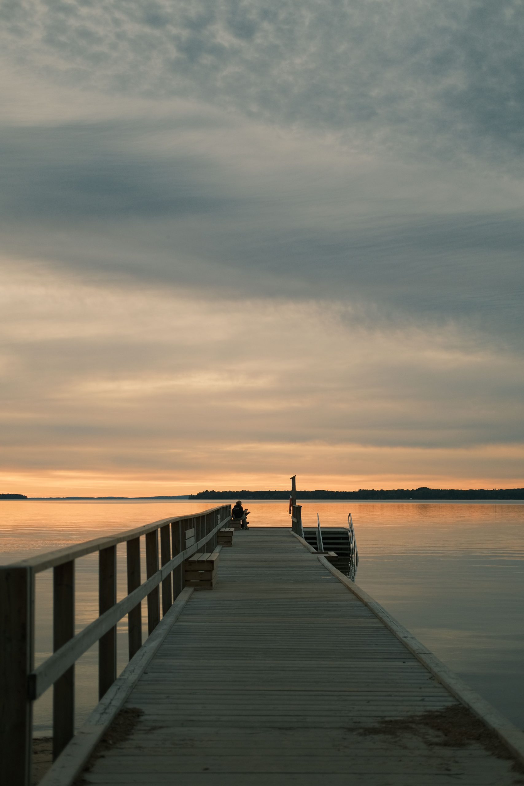 A wooden dock on a calm lake at sunrise