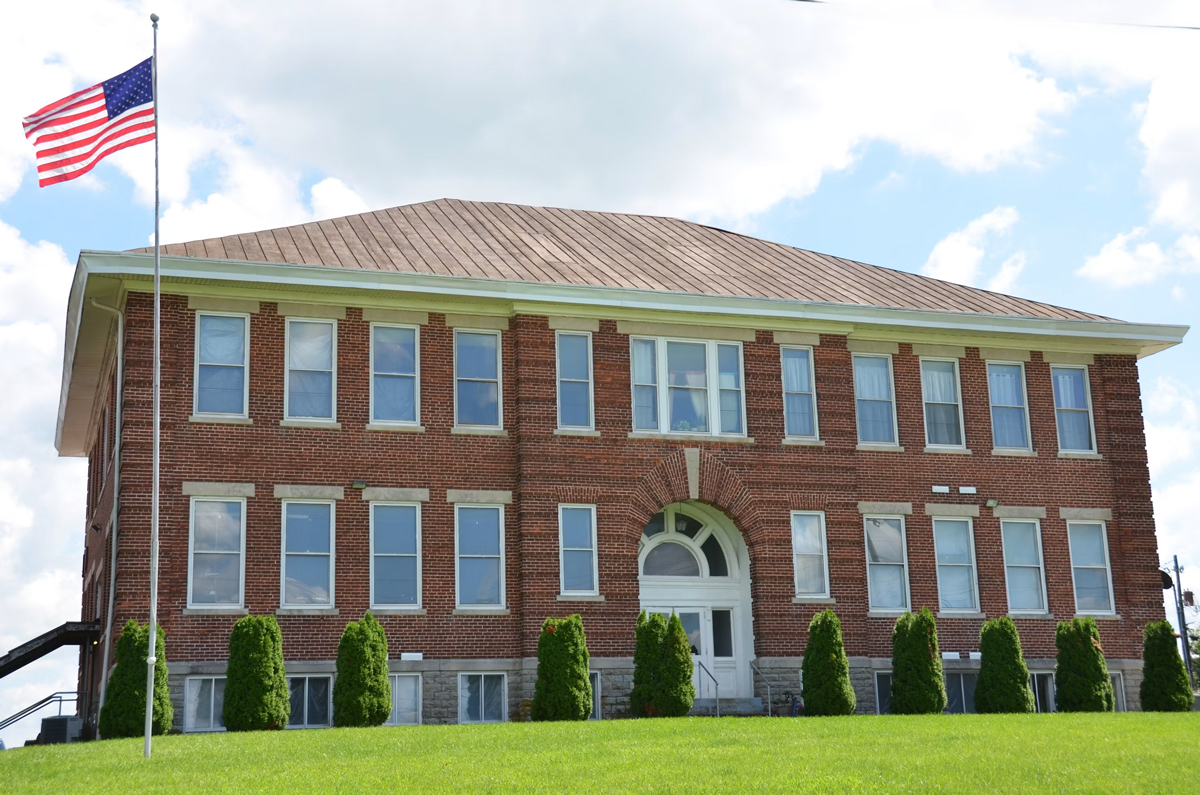A brick school building with an American flag